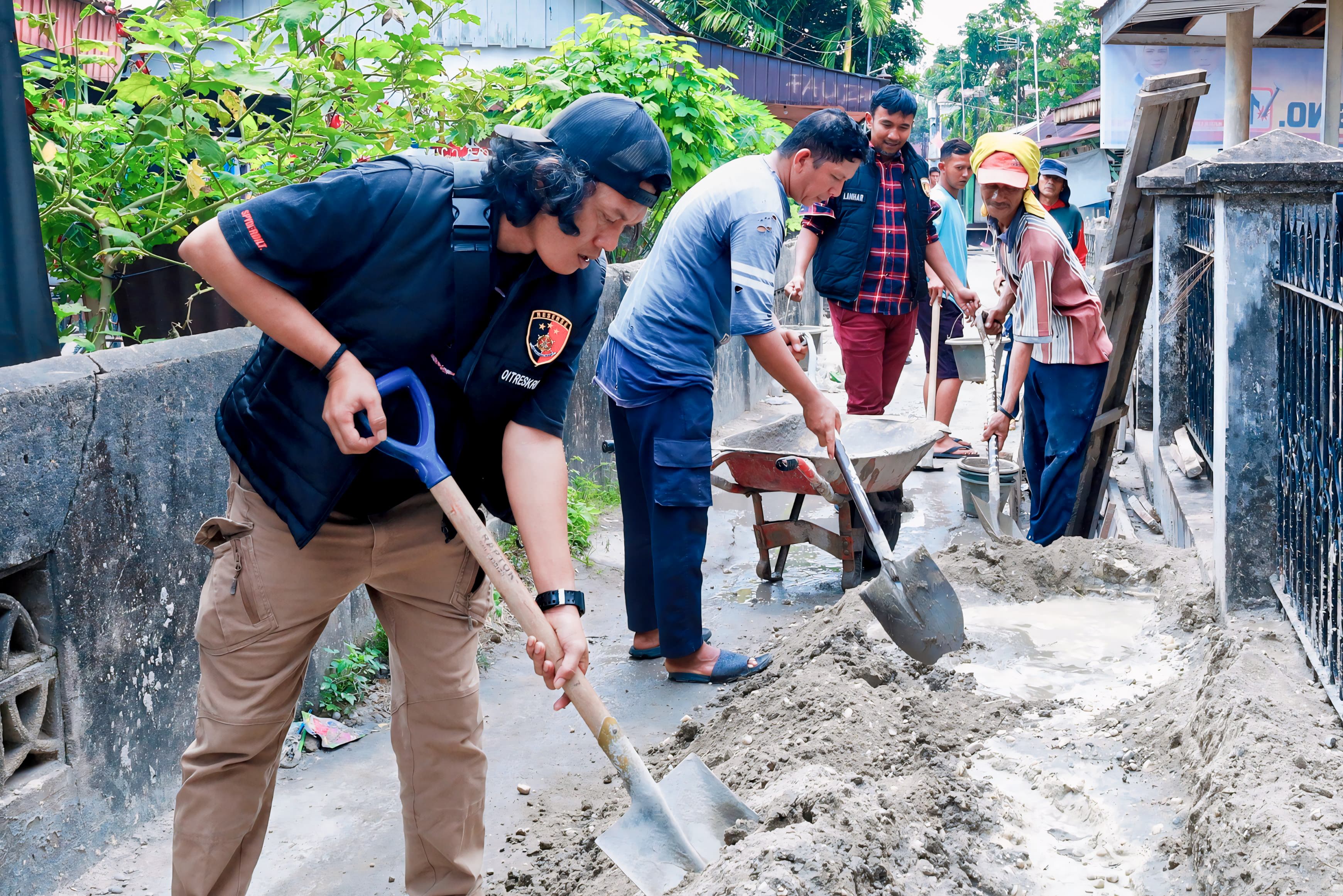 TIDAK TAKUT KOTOR, PERSONEL DITRESKRIMUM POLDA RIAU IKUT PENGECORAN PARIT JALAN DI PERUMAHAN WARGA